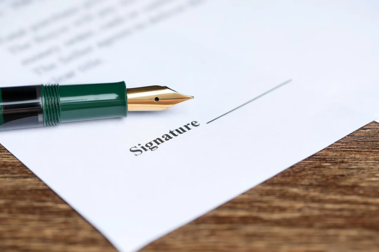 Documents and a pen on a desk, shallow depth of field, navy tones
