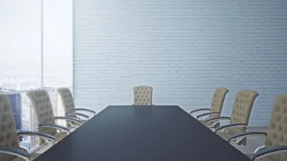 An empty boardroom table set for a governance review