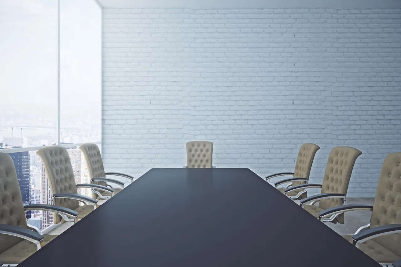An empty boardroom table set for a governance review
