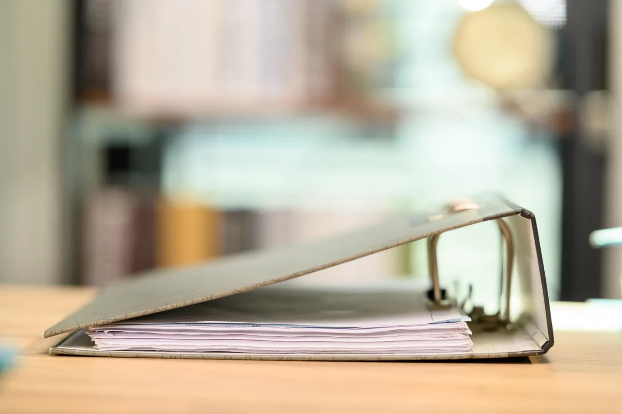 Isle of Man corporate documents and a compliance file on a navy desk