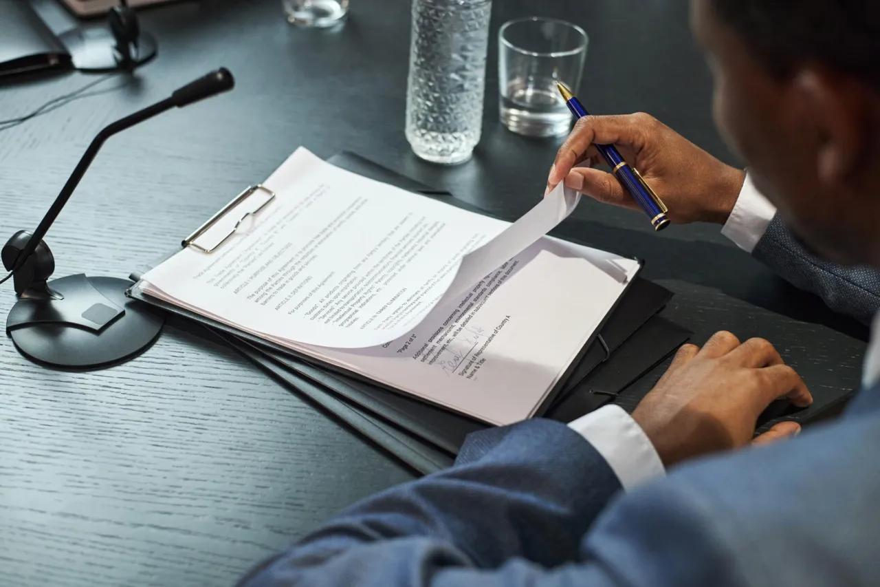 A close-up of a compliance policy document with sanctions procedure text highlighted