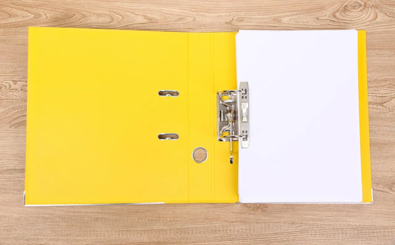 A compliance file open on a desk in a calm Isle of Man office