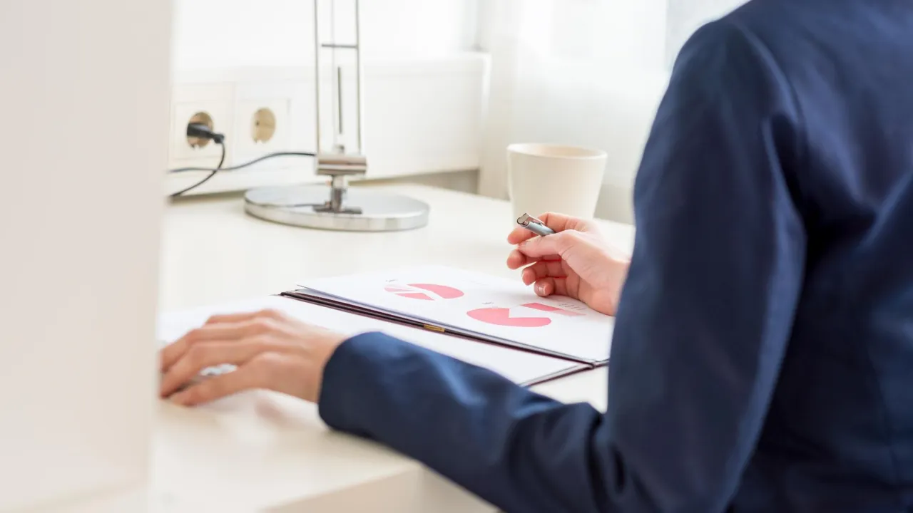 A person at a desk studying a printed chart