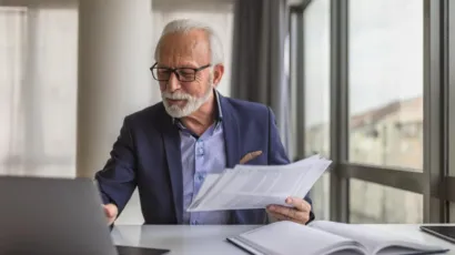 A senior compliance officer at a desk reviewing an internal disclosure in a calm Isle of Man office