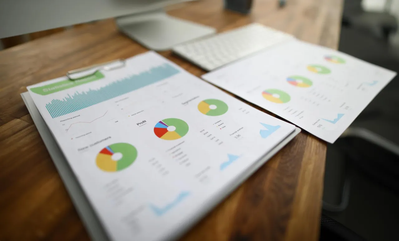 Printed reports with charts laid out on a wooden table
