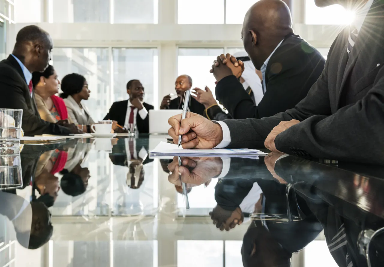 An international group in discussion around a boardroom table