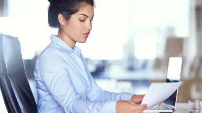 A compliance officer reviewing personal data records at an Isle of Man office desk
