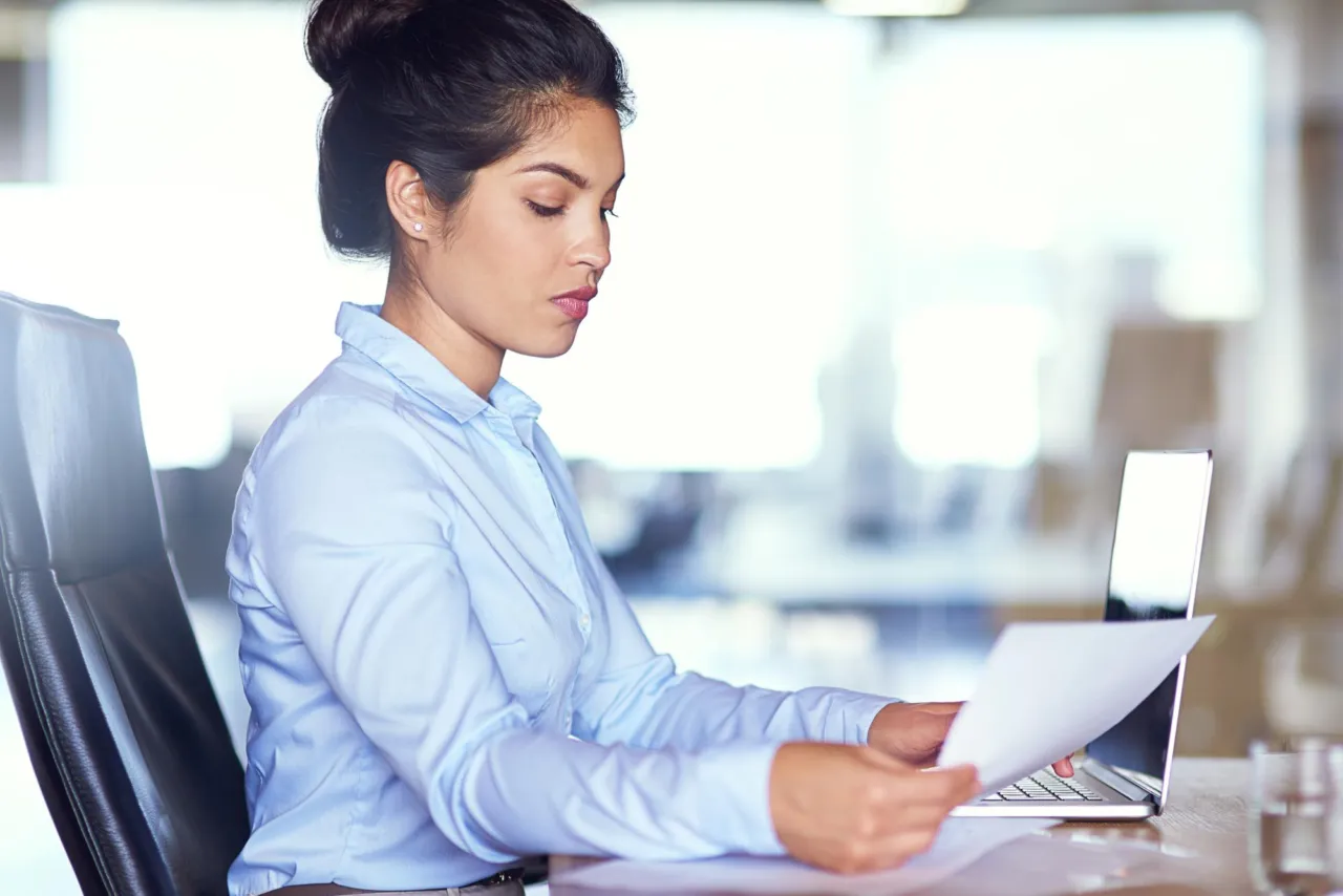 A compliance officer reviewing personal data records at an Isle of Man office desk