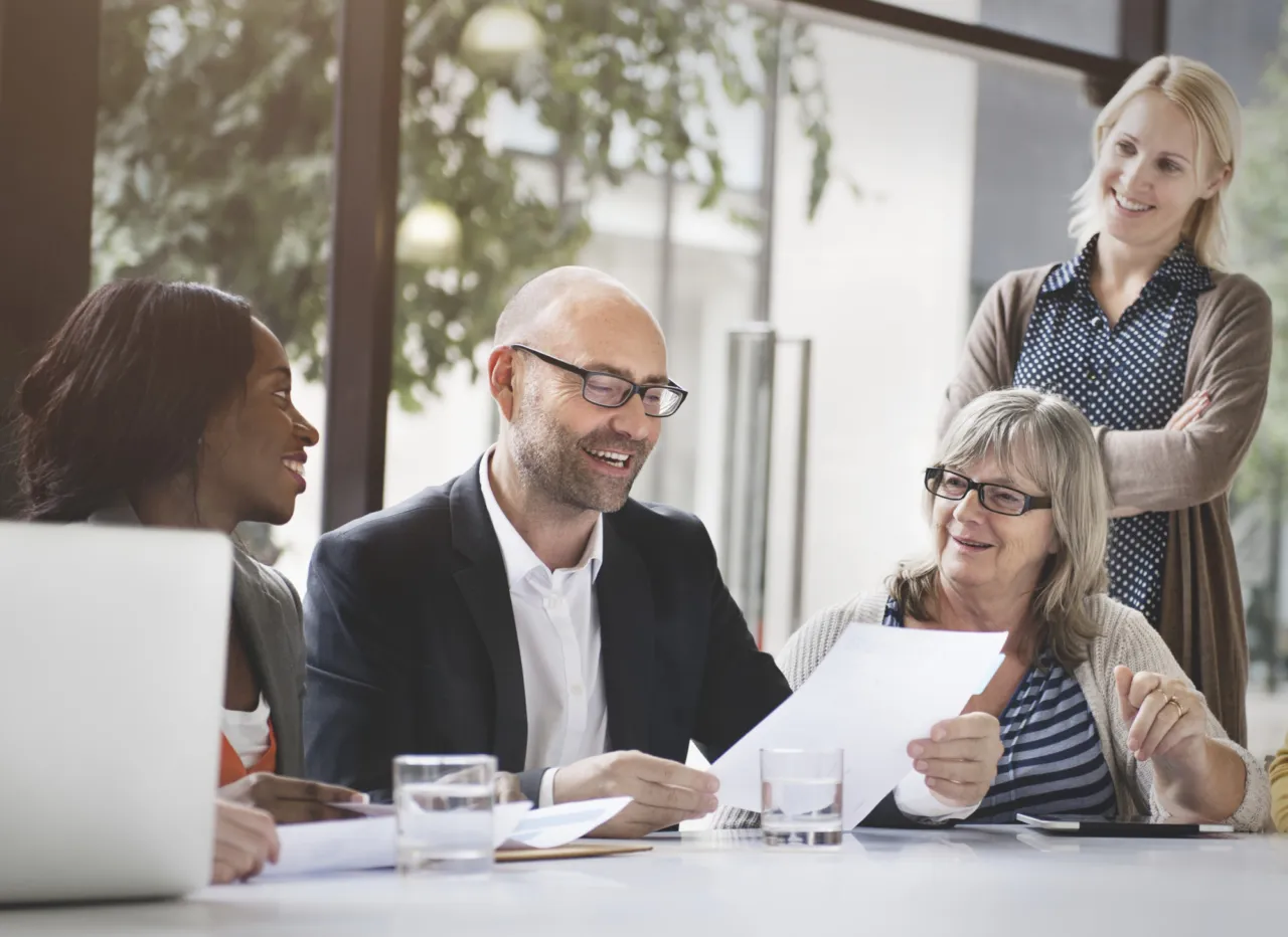 Colleagues around a table discussing a document together