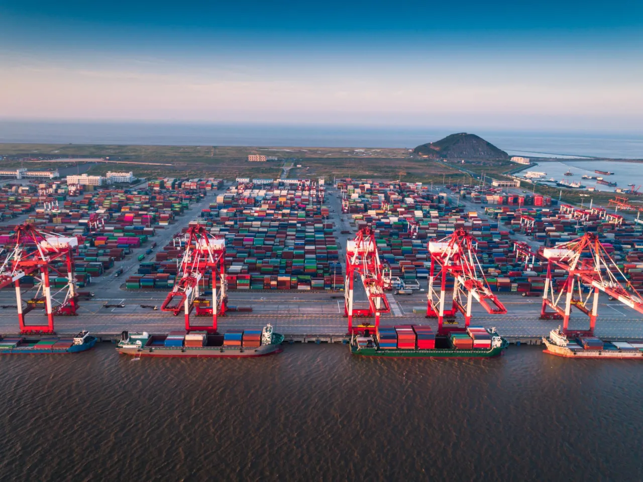 An aerial view of a container port with stacked freight