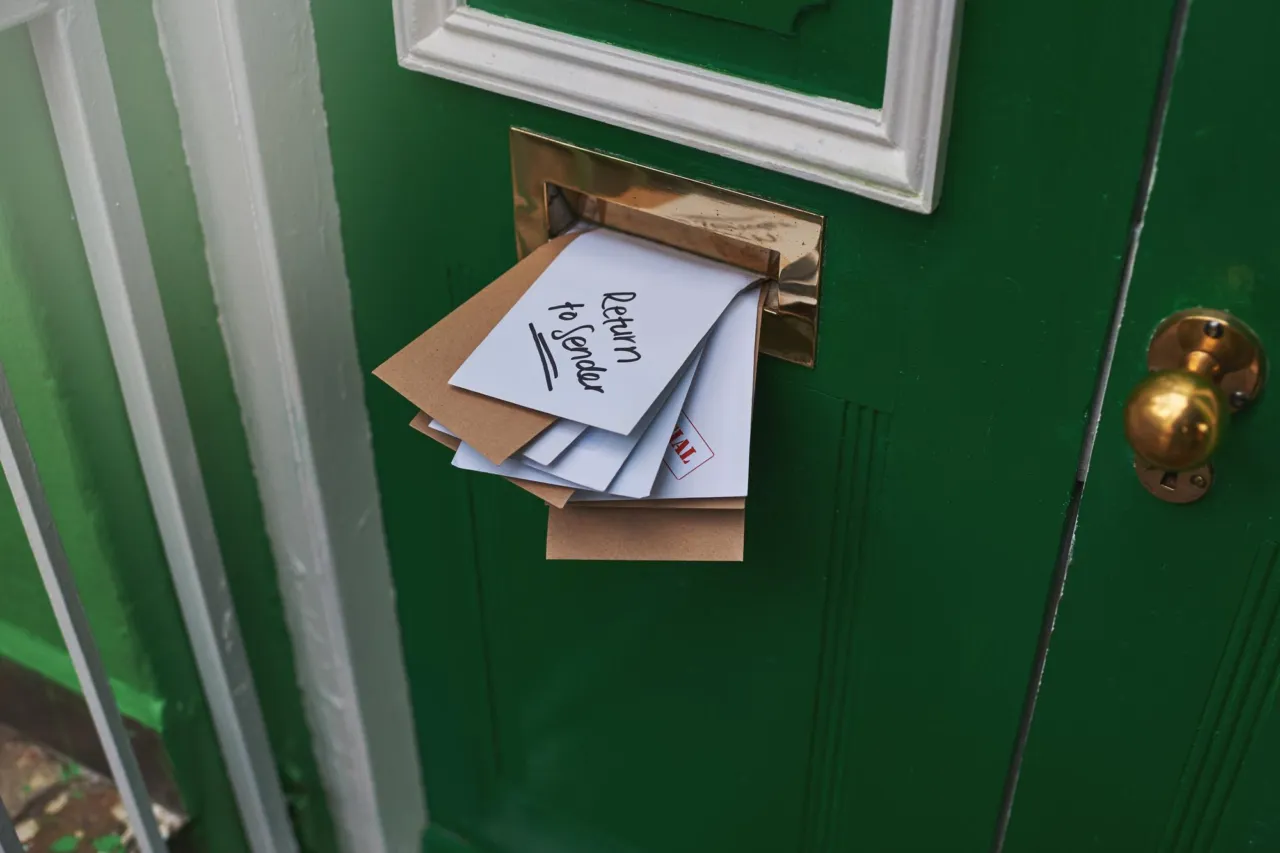 Letters protruding from the letterbox of a front door